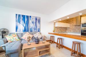a living room with a couch and a kitchen at Luxury Villas Anjomacar in Teguise
