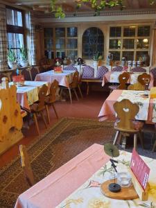 a restaurant with tables and chairs with pink tablecloths at Landgasthof Rotlipp Gästezimmer in Ortenberg