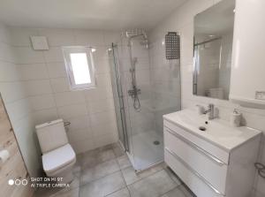 een badkamer met een douche, een toilet en een wastafel bij LEŚNA OSTOJA in Rewal +27 foto's