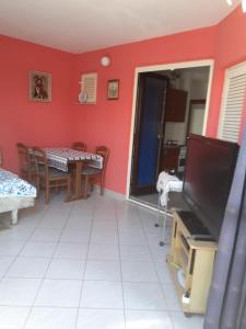 a living room with a television and a dining room at Josip 1 Gajac in Novalja
