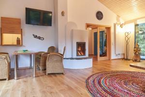 a living room with a fireplace and a table and chairs at Bio-Ferienhaus-Eifel in Rott