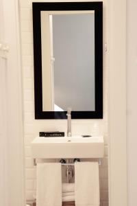 a bathroom with a white sink and a mirror at Hotel Almirante in Alicante