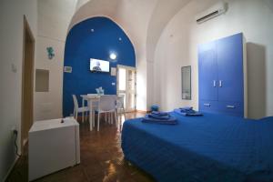 Un dormitorio con una cama azul y una mesa en B&B Zì Micheli Salento, en Castrignano del Capo