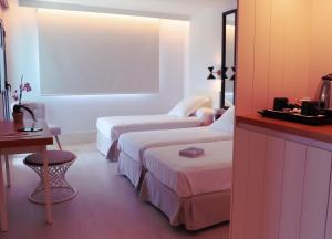 a hotel room with two beds and a table at Hotel Almirante in Alicante