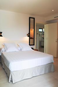 a large white bed in a bedroom with a mirror at Hotel Almirante in Alicante