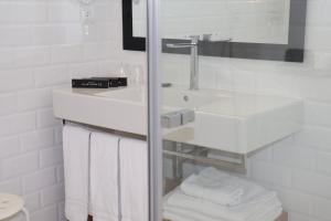 a white bathroom with a sink and a toilet at Hotel Almirante in Alicante