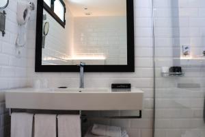 a white bathroom with a sink and a mirror at Hotel Almirante in Alicante