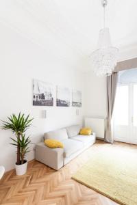 a white living room with a white couch and a rug at BpR Sophisticated Astoria Suite with Balcony in Budapest