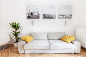 a white couch in a living room with pictures on the wall at BpR Sophisticated Astoria Suite with Balcony in Budapest