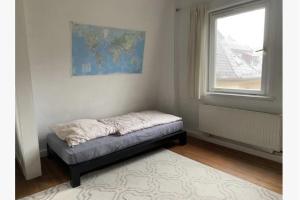 una piccola camera con un letto in una stanza con finestra di Altbauwohnung Stuttgart Ost a Stoccarda