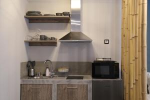 a kitchen with a sink and a microwave at Rooster Suites in Athens