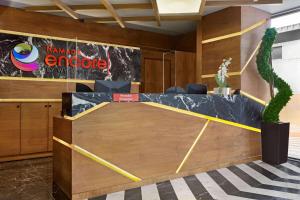 a reception desk in a lobby with a table at Ramada Encore by Wyndham Istanbul Avcilar in Istanbul