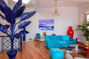 a living room with a blue couch and a blue plant at Villa Selena - 1830s Art-House Suites in Vaporia, 50m from Asteria Beach in Ermoupoli
