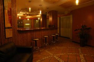a room with a bar with stools in it at Alajuela Backpackers Airport Hostel in Alajuela