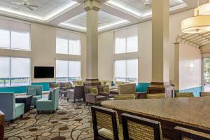 Cette grande chambre dispose de tables, de chaises et de fenêtres. dans l'établissement Comfort Inn & Suites Sarasota I75, à Sarasota