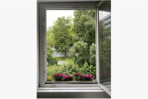 una ventana abierta con un alféizar de flores en Altbauwohnung Stuttgart Ost, en Stuttgart