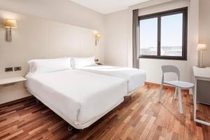 1 dormitorio con 1 cama blanca grande y 1 silla en B&B HOTEL Elche, en Elche 25 fotos más