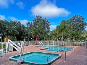 ein Schwimmbad in einem Park mit einem Metallzaun in der Unterkunft Comfort Inn & Suites Sarasota I75 in Sarasota