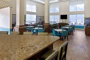 a dining room with tables and chairs and windows at Comfort Inn & Suites Sarasota I75 in Sarasota