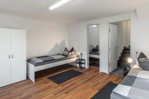 a white bedroom with a bed and a mirror at Ferienwohnung Ohechaussee in Norderstedt