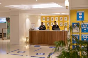 dos hombres sentados en un mostrador en el vestíbulo en Fortune Resort Grace, Mussoorie - Member ITC's Hotel Group, en Mussoorie