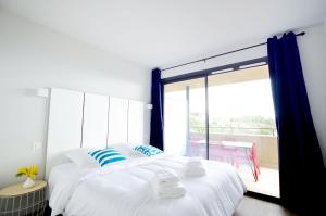a bedroom with a large bed and a balcony at La Perle d'Eze - Aparthotel in Éze