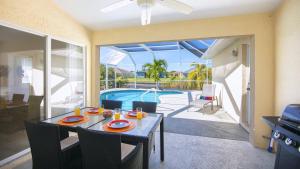 ein Esszimmer mit einem Tisch und einem Pool in der Unterkunft !NEW! Villa Waterview in Cape Coral
