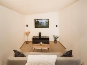 a living room with two couches and a table at Chalet Wolfbachgut in Taxenbach