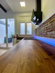 Cette chambre est dotée de parquet et d'un mur en briques. dans l'établissement Casa adosada a 20 min centro de Barcelona, à L'Hospitalet de Llobregat 15 autres photos