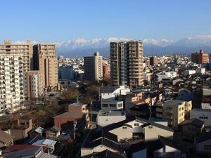 富山市にある富山マンテンホテルの建物や山々を背景にした都市