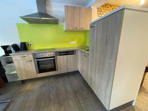 a kitchen with wooden cabinets and a stove top oven at Ferienwohnung Sonnenaufgang in Amtzell