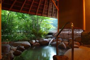 a pool of water in a room with a window at Kinosaki Onsen Nishimuraya Hotel Shogetsutei in Toyooka