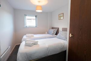 a bedroom with two beds with towels on them at Spacious House in Sheffield - Great Location! in Attercliffe