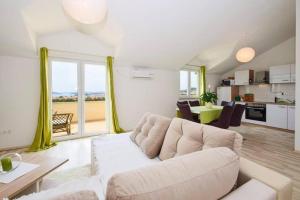 Apartments Marjanovic في فوديس: غرفة معيشة مع أريكة بيضاء ومطبخ