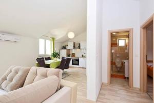 Apartments Marjanovic في فوديس: غرفة معيشة بيضاء مع أريكة ومطبخ