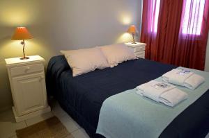 - une chambre avec un lit et des serviettes dans l'établissement Willy HOSTEL, à San Rafael