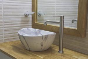 een badkamer met een komvormige wastafel voor een spiegel bij נווה חרמון in Majdal Shams