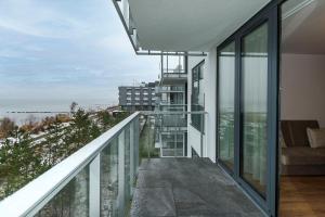 a balcony with glass walls and a view of the ocean at VacationClub – Jantaris Apartament A 35 in Mielno