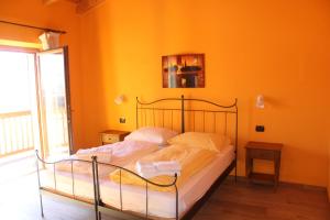 1 dormitorio con 2 camas y pared de color naranja en Maso Fiorini, en Rovereto