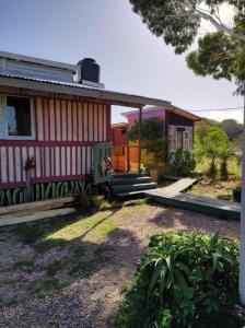 una casa con un porche y un banco frente a ella en Biodiversidad posada familiar, en La Pedrera