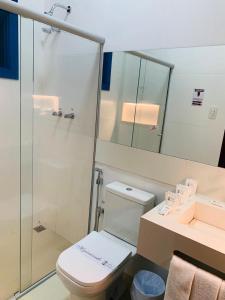 a bathroom with a shower and a toilet and a sink at Hotel Lenheiros in São João del Rei