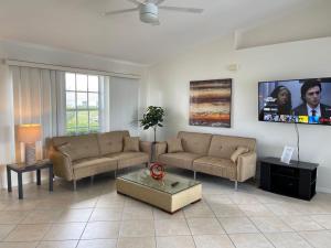 ein Wohnzimmer mit zwei Sofas und einem Fernseher in der Unterkunft !NEW! Villa Waterview in Cape Coral