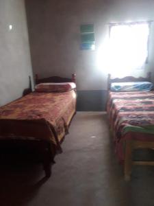 2 camas en una habitación con ventana en ALOJAMIENTO SANTY en Iruya