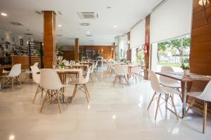 un restaurante con mesas y sillas en una habitación en Checkin Valencia Alaquas, en Alacuás