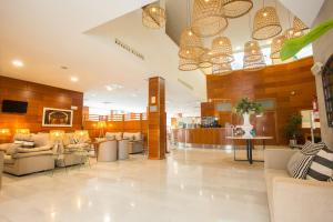 a lobby with couches and tables and chandeliers at Checkin Valencia Alaquas in Alaquas