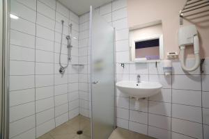 a white bathroom with a sink and a shower at Abraham Tel Aviv in Tel Aviv