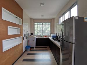 a large kitchen with a refrigerator and a window at Eden 8pax 3Rooms apartment near Kuching Airport in Kuching