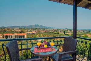 a table with two glasses of orange juice on a balcony at Notos Studios in Laganas