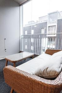 1 dormitorio con cama de ratán y ventana grande en SleepWell Apartment Rio with private sauna and parking en Helsinki