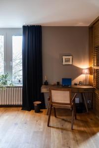 Zimmer mit einem Schreibtisch und einem Laptop darauf in der Unterkunft The Pastorini in Zürich